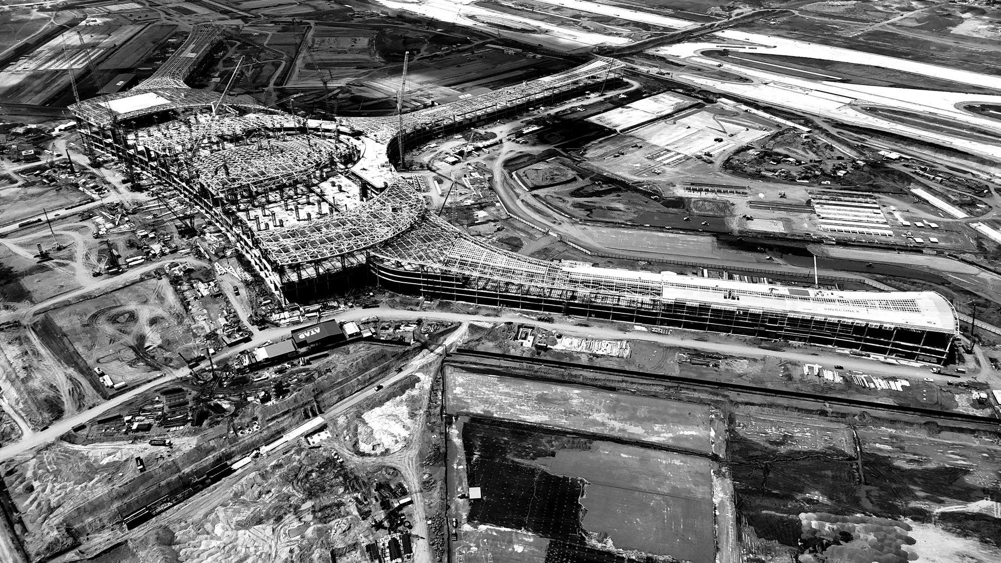 Aerial view of a large infrastructure project under construction, with earthworks and access roads.